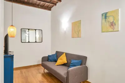 a living room with a gray couch with blue pillows at Trinity Apartment in Rome