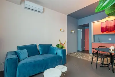a living room with a blue couch and a table at MARCANTONIO HOME ROME - Vatican - in Rome