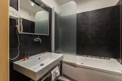 a bathroom with a white sink and a tub at San Marco City View Rooms in Rome