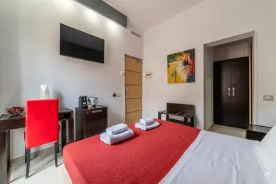 a bedroom with a red bed with a red blanket at San Marco City View Rooms in Rome
