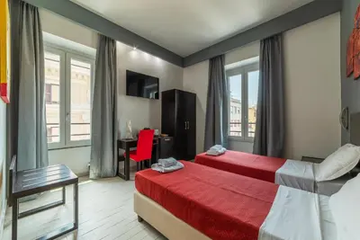 a hotel room with two beds and a desk at San Marco City View Rooms in Rome