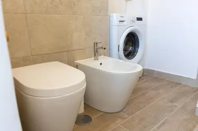 a bathroom with a toilet and a washing machine at Casa Vacanze Ottaviano 25 in Rome