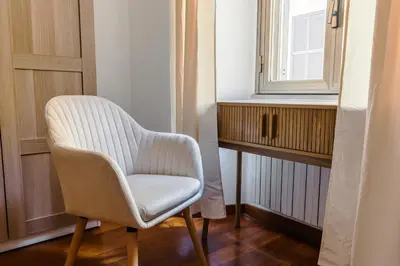 a white chair sitting next to a window at Casa Vacanze Ottaviano 25 in Rome