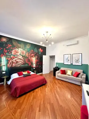 a bedroom with a large red bed and a couch at Vacanze Romane Suite 7 Languages in Rome
