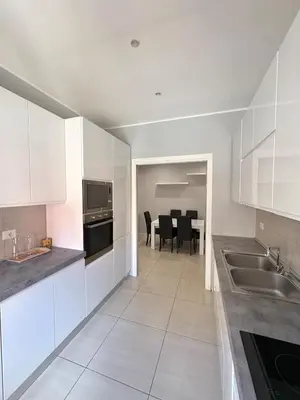 a kitchen with white cabinets and a table with chairs at Fortis Domus in Rome