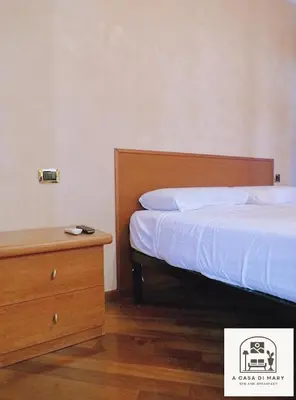 a bedroom with a bed and a wooden dresser at A Casa di Mary in Rome