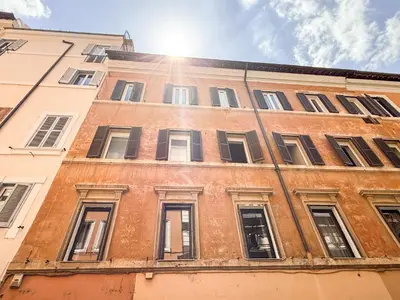 a brick building with windows and the sun in the sky at The Rubens Spagna in Rome