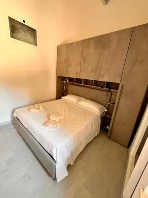 a small bedroom with a bed with white sheets at Pigneto Holiday Home in Rome