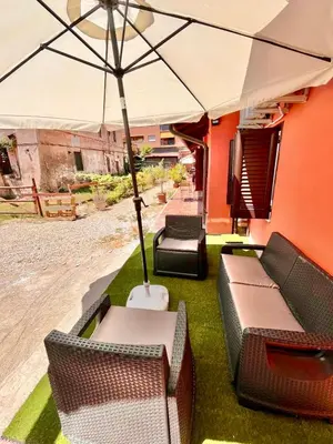 an outdoor patio with chairs and an umbrella at Pigneto Holiday Home in Rome