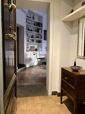 a hallway with a door leading to a room with a table at 7550rome P&J's cozy Trastevere Apartment in Rome