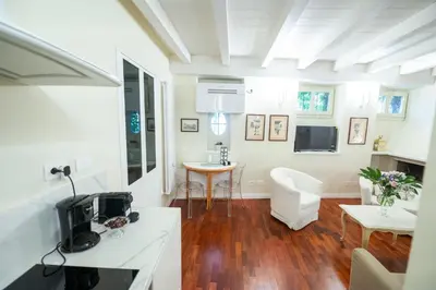 a kitchen and living room with a table and a tv at Piazza Navona Ivy Retreat- Under the Roman Light in Rome