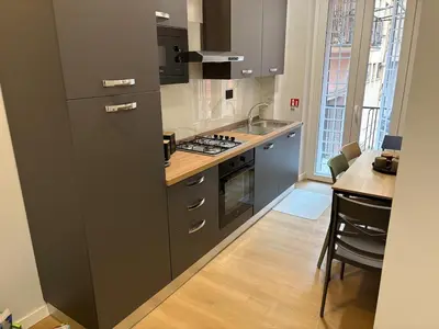 a kitchen with a sink and a stove top oven at Masonber trastevere centro Wi-Fi free balcone metro in Rome