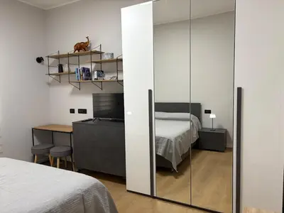 a bedroom with a bed and a desk and a mirror at Masonber trastevere centro Wi-Fi free balcone metro in Rome