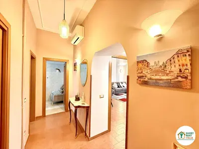 a room with a hallway with a table and a painting on the wall at San Giovanni - Minerva House in Rome