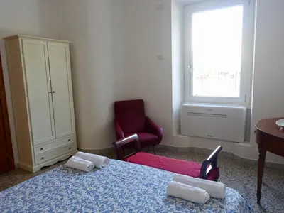 a room with a bed and a chair and a window at PiccoloPrincipeAirbnb - Saint Peter area in Rome