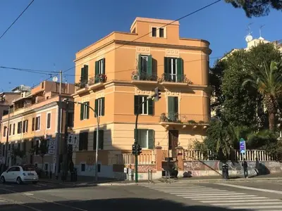 a large yellow building with green shutters on a street at Centralissima Collegatissima in Rome