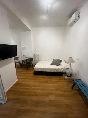 a white room with a bed and a table at Mina's House in Rome