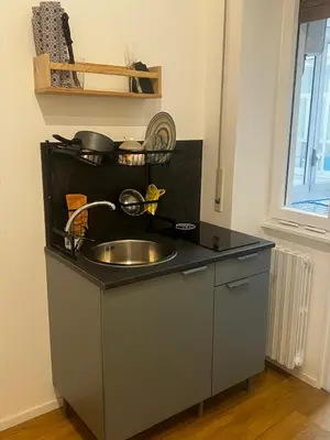 a kitchen with a sink and a shelf with pots and pans at Mina's House in Rome