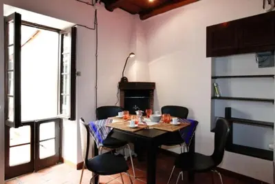 a dining room with a table and chairs and a fireplace at 931 Rome Montefiore apartment in Rome