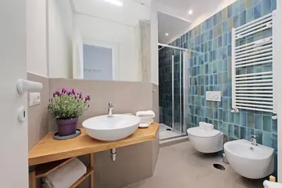a bathroom with two sinks and a toilet at Brand New Modern Apt 2 Stops to Colosseum in Rome