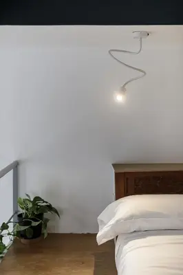 a bedroom with a bed with a lamp and a plant at Casina Albani in Rome