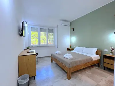 a bedroom with a bed and a desk and a window at Casa della Musica - Guesthouse in Rome