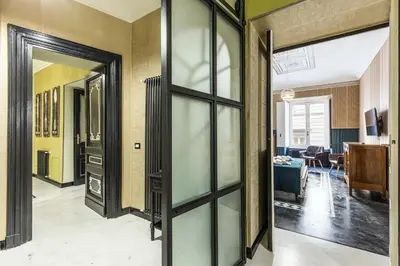 a hallway with glass doors and a living room at Rome As You Feel - Maison Torre Argentina - Arenula 41 in Rome