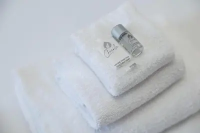 a white towel with a bottle of soap on it at Candy Lodge in Rome