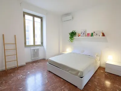 a white bedroom with a bed and two lamps at Enjoy Rome San Paolo Retreat in Rome