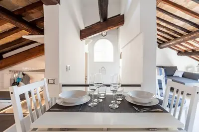 a dining room with a table with wine glasses at Renovated Luxury Sweet Penthouse - Campo Dei Fiori in Rome
