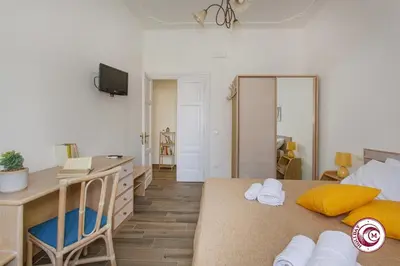 a bedroom with a desk and a bed with towels at Domus Latina heart San Giovanni in Rome