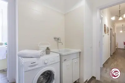 a white laundry room with a washing machine and a sink at Domus Latina heart San Giovanni in Rome