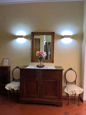 a bathroom with a vanity with a mirror and two chairs at Vatican Lodge in Rome