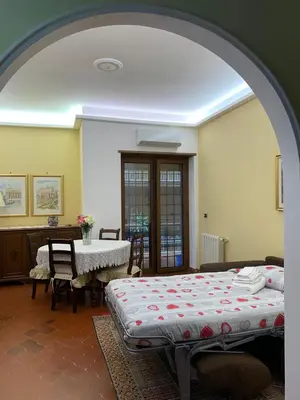 a bed sitting in a living room with a table at Vatican Lodge in Rome