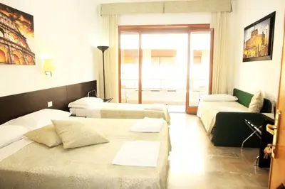 a hotel room with two beds and a couch at Le tue Notti a San Pietro in Rome