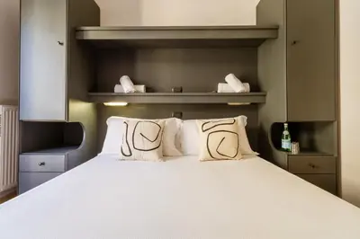 a bedroom with a bed with white sheets and pillows at Cunabu Calatafimi in Rome