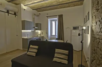 a living room with a couch and a kitchen at Appartamento Pigneto in Rome