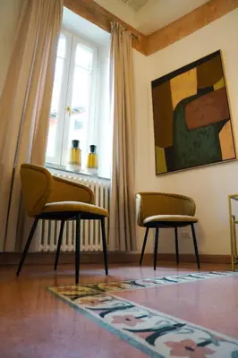 a living room with two chairs and a rug at Trastevere Luxury Apartment in Rome