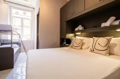 a bedroom with a large bed with white sheets and pillows at Cunabu Castro Pretorio in Rome