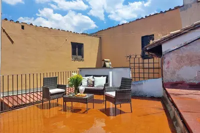 a patio with chairs and a couch on a balcony at Quiet nest in Campo De' Fiori in Rome