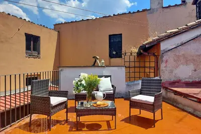 a patio with three chairs and a table and a couch at Quiet nest in Campo De' Fiori in Rome