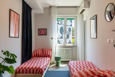 a living room with two chairs and a window at GuestHost - Colorful Apt in Vintage-Modern Style in Rome
