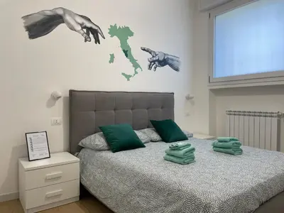 a bedroom with a bed with two hands on the wall at Family Domus Via Latina in Rome