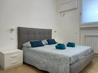 a bedroom with a bed with blue towels on it at Family Domus Via Latina in Rome