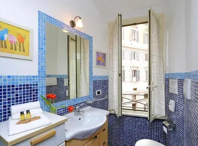 a blue tiled bathroom with a sink and a mirror at 600mt To Colosseum in Rome