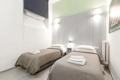 two beds in a white room with towels on them at Rome Capital Apartments in Rome