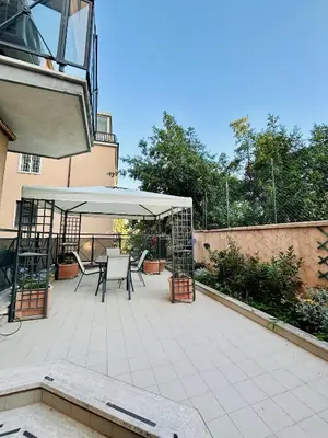 a patio with a table and chairs and an umbrella at casa di Stefano in Vaticano in Rome