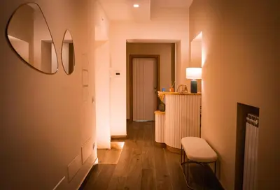 a hallway with a table and a chair and a mirror at Alma Guest House in Rome