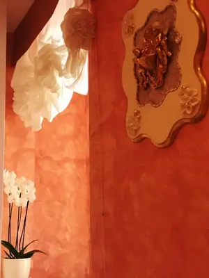 a wall with a mirror and a vase of flowers at Pope's Suites in Rome