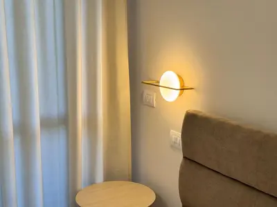 a lamp on a wall next to a couch at Luxury Apartment Metro Cornelia in Rome
